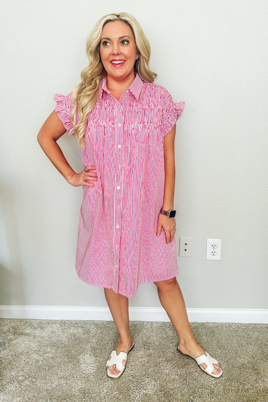 Full-length front view of a woman wearing a red and white striped boutique dress. The Lexington Shirtdress is paired with white slide sandals and available from this Texas boutique.