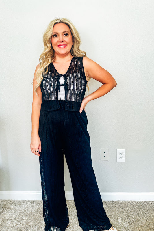 Woman wearing black crochet vacation outfit, from a resort wear collection at a Texas boutique.