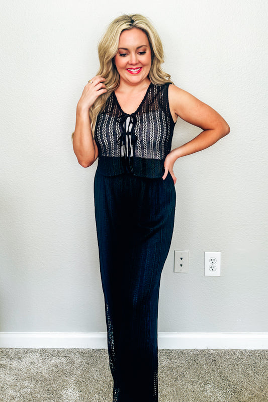 Woman wearing the black open-stitch crochet tie-front vest top from the resort wear collection at a Texas boutique.