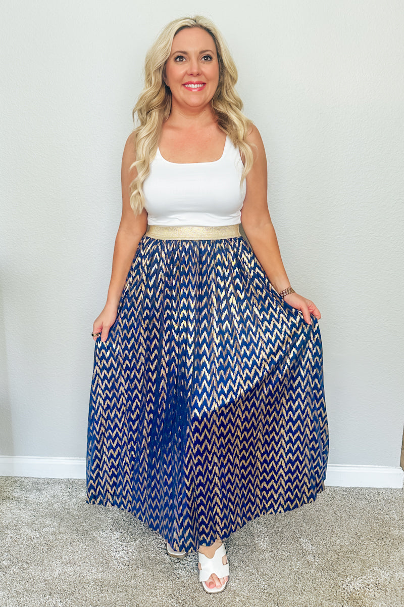 Full-length view of the Monaco Metallic Pleated Skirt styled with white slide sandals, highlighting casual yet glamorous resort wear from this Texas boutique.
