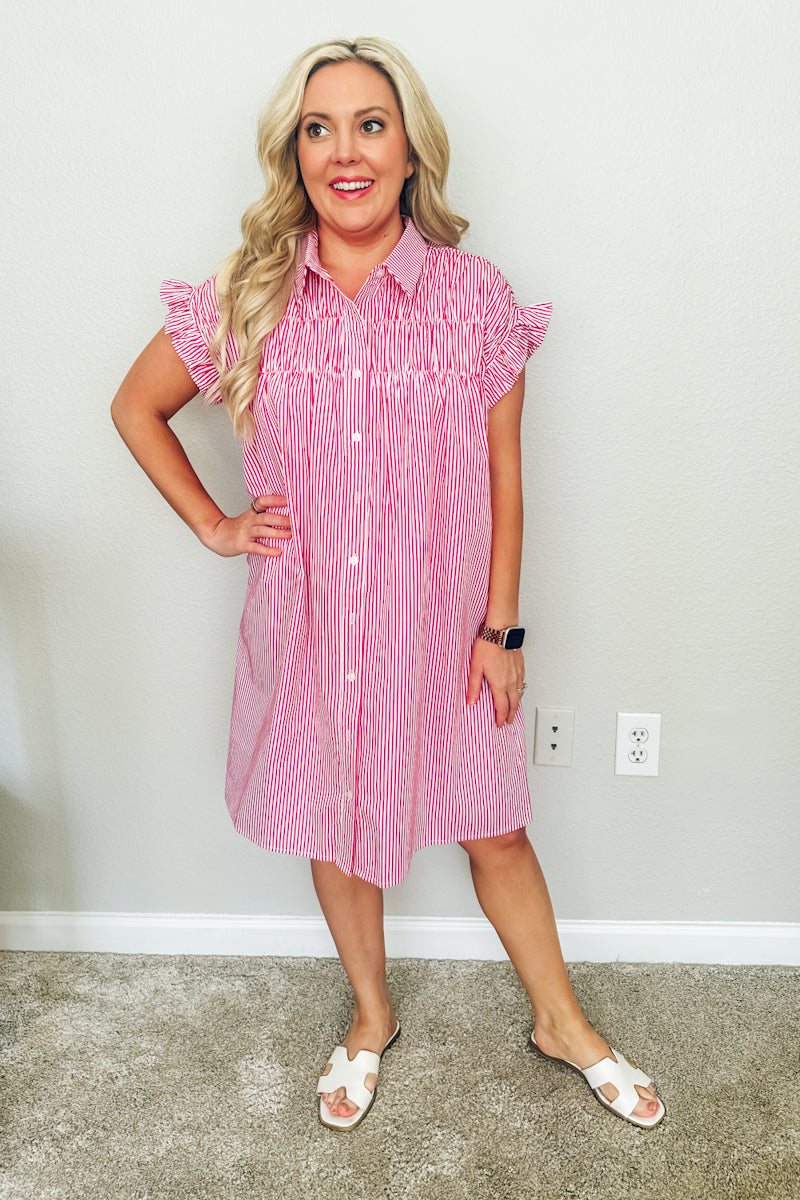 Full-length front view of a woman wearing a red and white striped boutique dress. The Lexington Shirtdress is paired with white slide sandals and available from this Texas boutique.